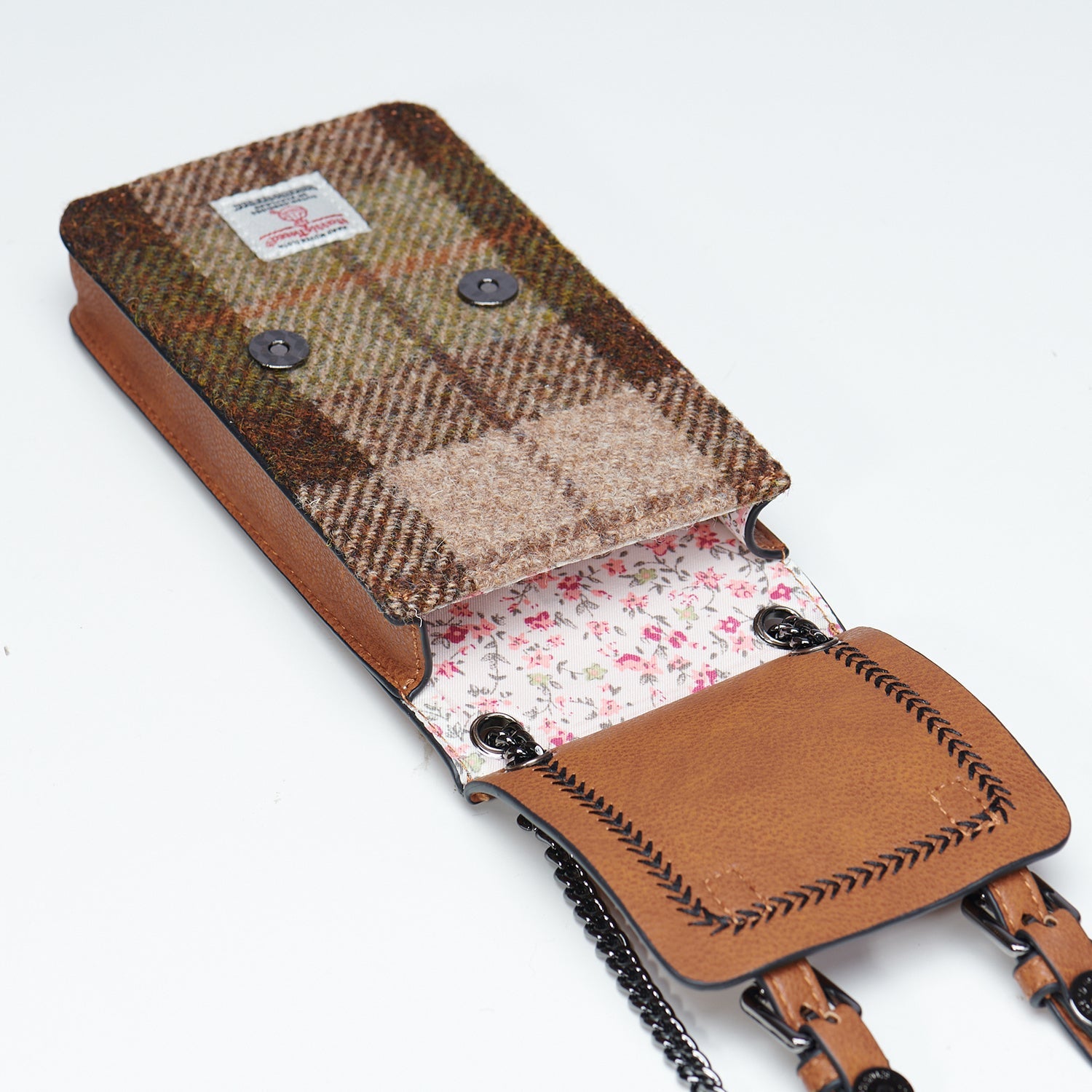 Two leather bags, one brown and one green, on a textured white surface.