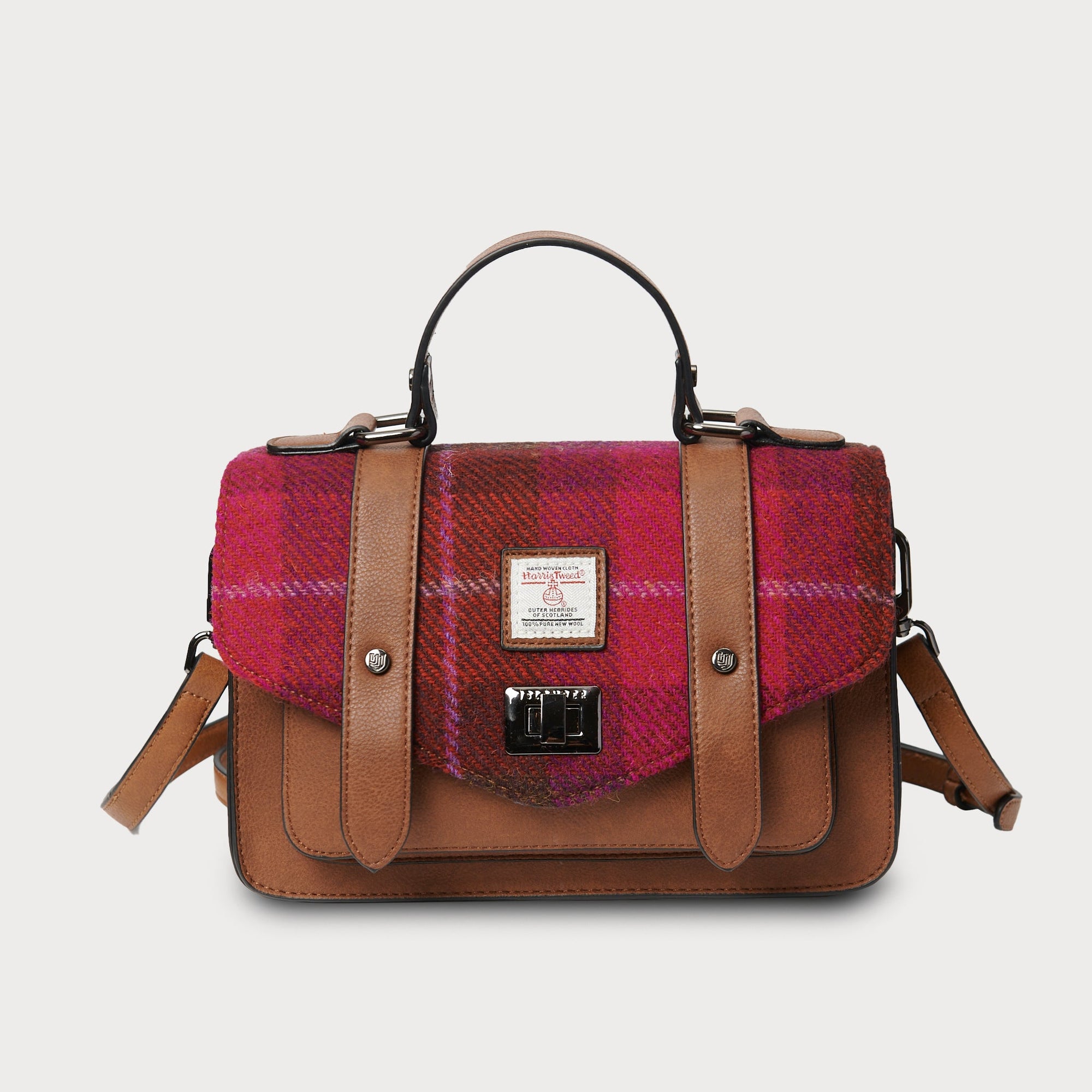 Plaid handbag with brown leather accents on a light gray background