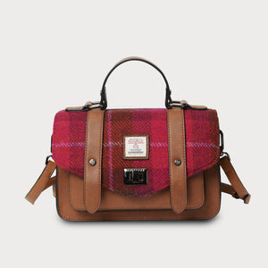 Plaid handbag with brown leather accents on a light gray background