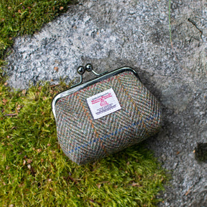 Textile coin purse on a stone surface with grass