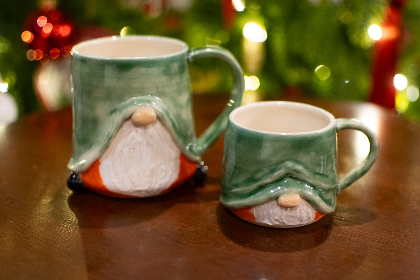 Green mug shaped like a gnome with a blurred Christmas tree in the background